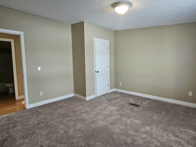 unfurnished room featuring carpet and a textured ceiling