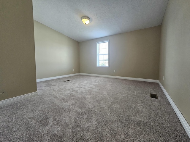 carpeted spare room with a textured ceiling