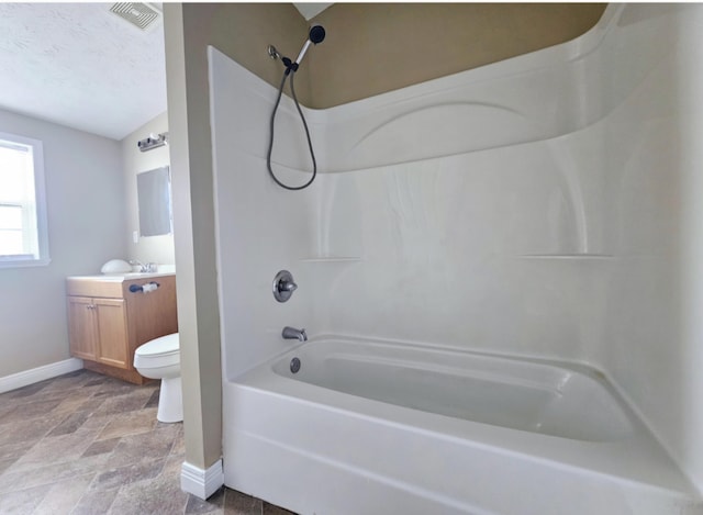 full bathroom with washtub / shower combination, vanity, a textured ceiling, and toilet