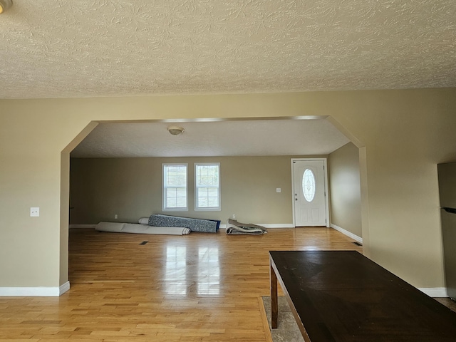 entryway with light hardwood / wood-style floors and a textured ceiling