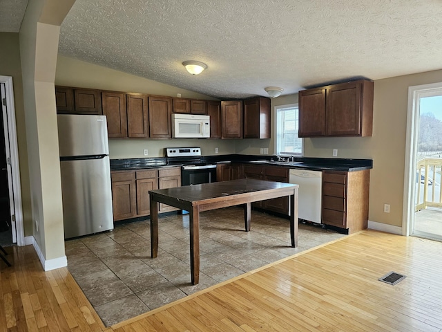 kitchen with a wealth of natural light, light hardwood / wood-style floors, and appliances with stainless steel finishes