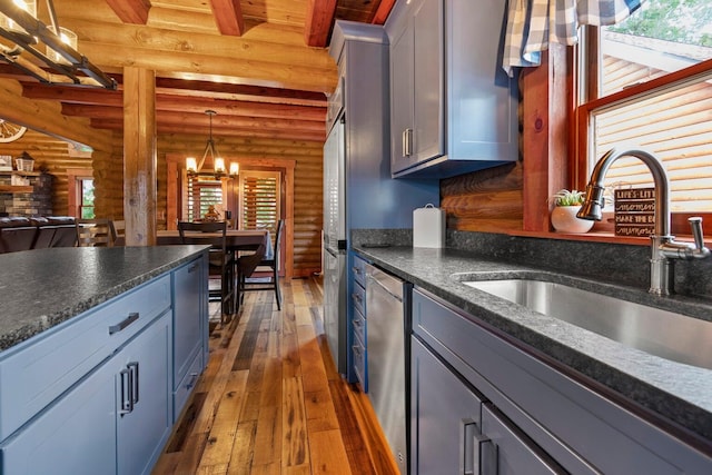 kitchen with sink, plenty of natural light, dark hardwood / wood-style flooring, and rustic walls