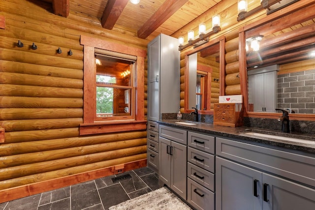 bathroom featuring vanity, beam ceiling, and log walls