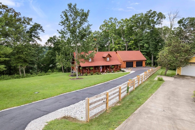 view of front of home featuring a front lawn, an outdoor structure, and a garage