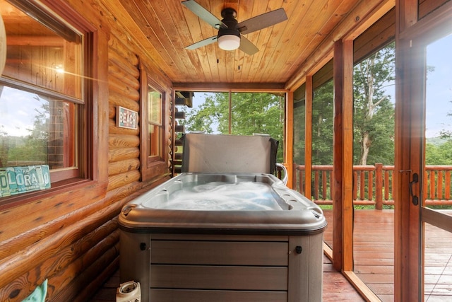 sunroom / solarium featuring ceiling fan, wooden ceiling, a wealth of natural light, and a hot tub