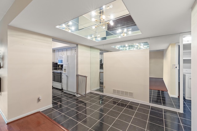 interior space with washer / clothes dryer and dark tile patterned floors