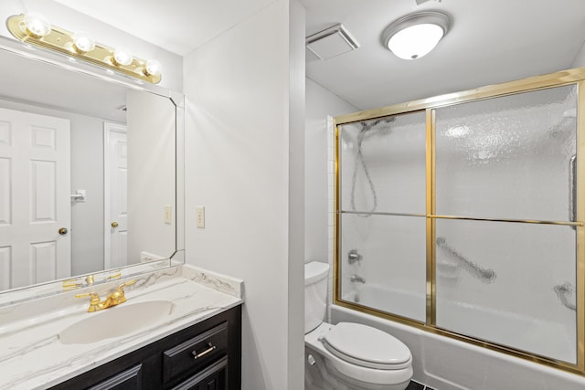 full bathroom featuring vanity, combined bath / shower with glass door, and toilet