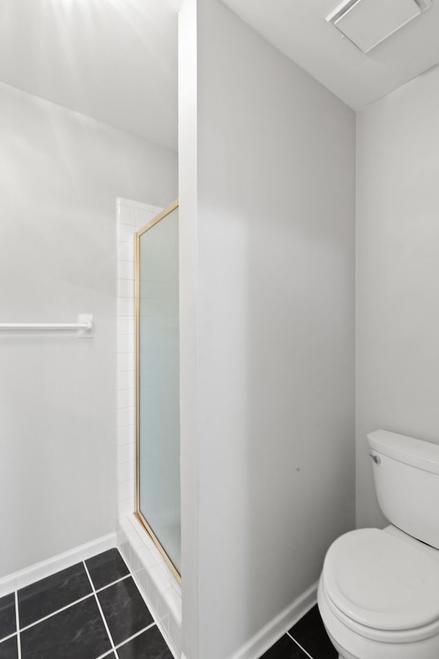 bathroom with tile patterned flooring, toilet, and walk in shower