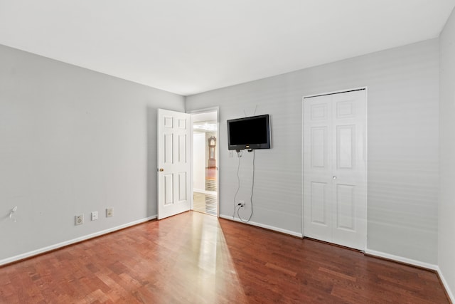 unfurnished bedroom featuring hardwood / wood-style flooring and a closet