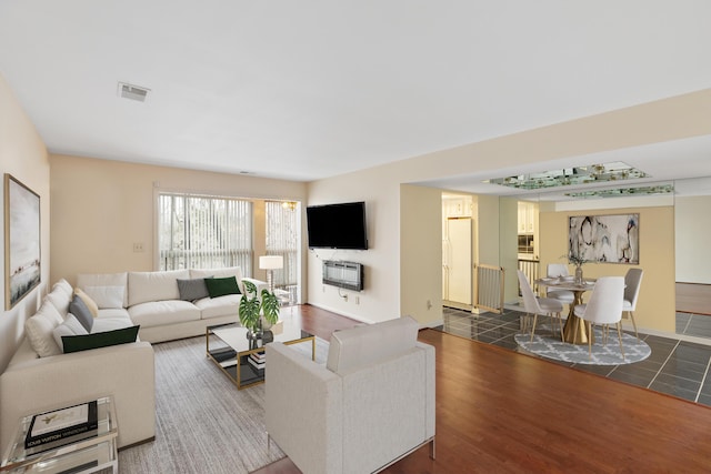 living room featuring dark wood-type flooring and heating unit