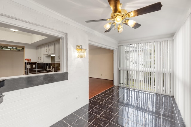 interior space with ornamental molding and ceiling fan