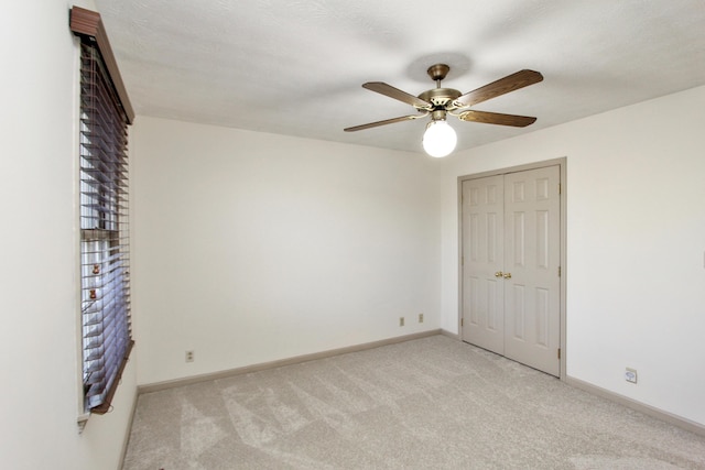 empty room with light carpet, a textured ceiling, and ceiling fan