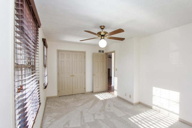 interior space with light colored carpet and ceiling fan