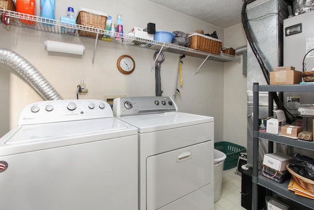 clothes washing area with washer and dryer and a textured ceiling