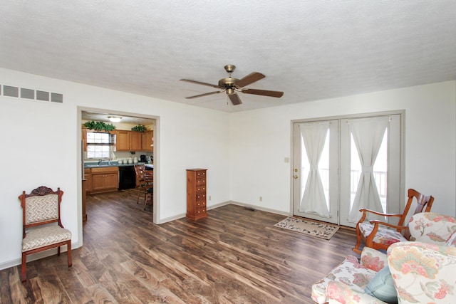 living room featuring sink, ceiling fan, dark hardwood / wood-style flooring, and a textured ceiling