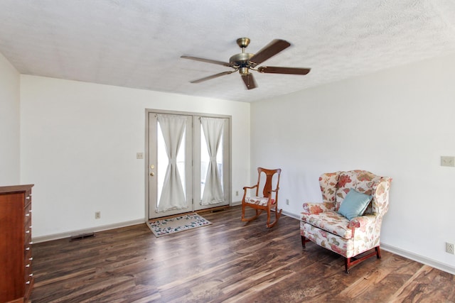 sitting room featuring a textured ceiling, ceiling fan, and dark hardwood / wood-style floors