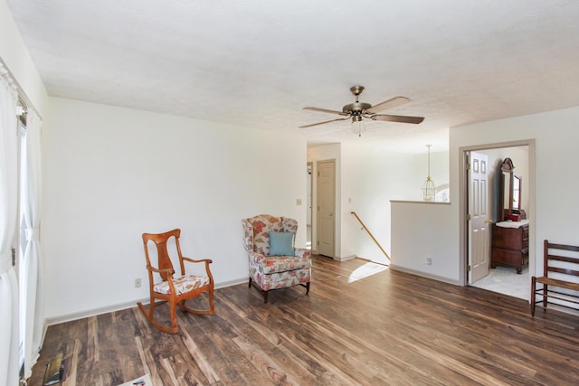 living area featuring a textured ceiling, dark hardwood / wood-style flooring, and ceiling fan