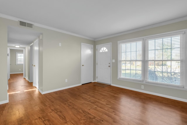 entrance foyer with crown molding, plenty of natural light, and hardwood / wood-style flooring