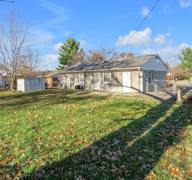 back of property featuring a lawn, central AC, a patio, and a shed