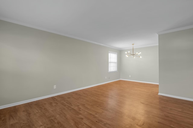 spare room with a notable chandelier, wood-type flooring, and crown molding