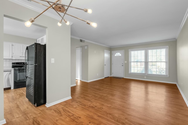 unfurnished living room with light hardwood / wood-style flooring, a chandelier, and ornamental molding