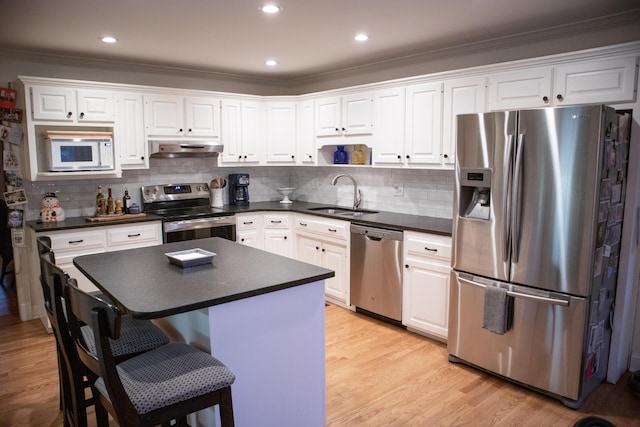 kitchen with decorative backsplash, white cabinetry, sink, and appliances with stainless steel finishes