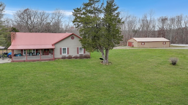 view of yard with a porch and an outbuilding