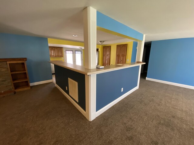 kitchen with dark colored carpet and kitchen peninsula