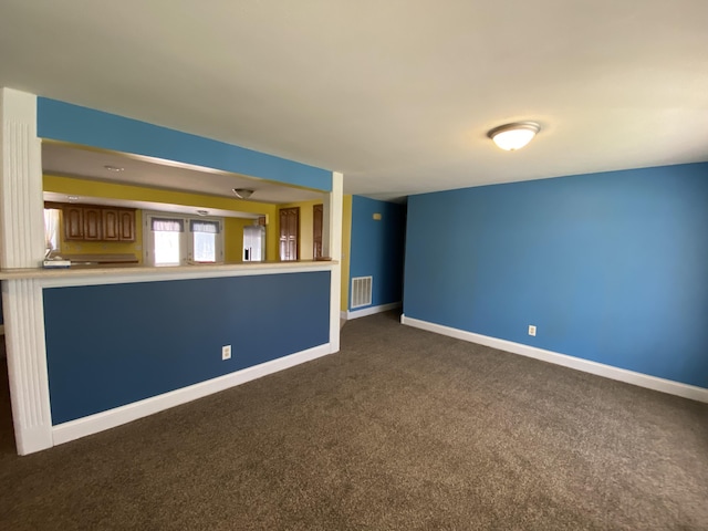 unfurnished living room with dark colored carpet