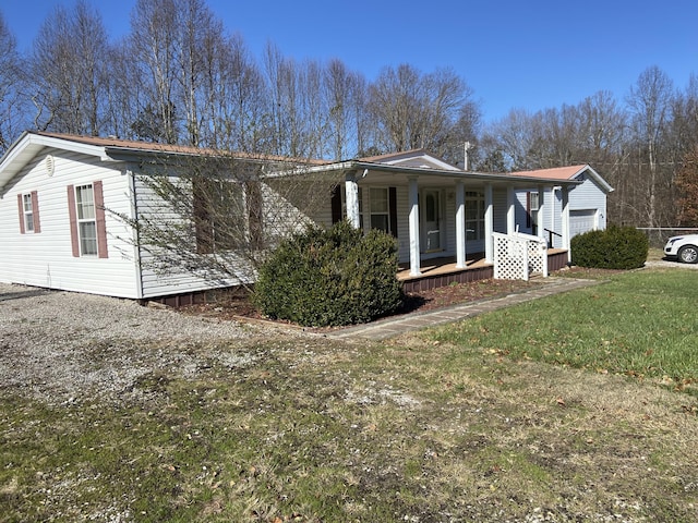 view of side of property with a porch and a lawn