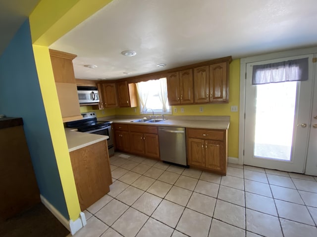 kitchen with light tile patterned floors, stainless steel appliances, and sink