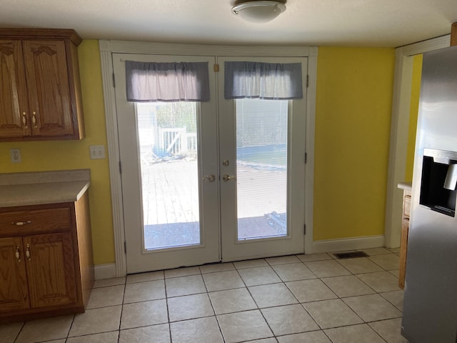 doorway featuring light tile patterned floors and french doors