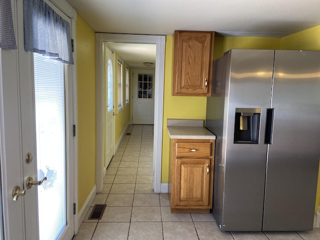 kitchen featuring light tile patterned floors and stainless steel refrigerator with ice dispenser