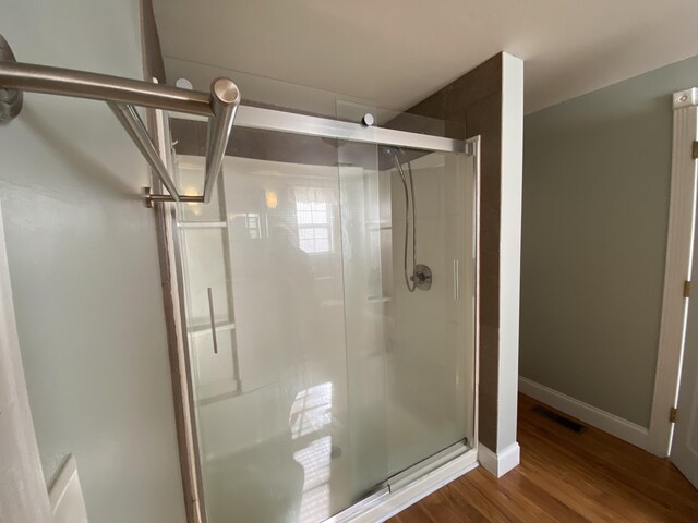 bathroom featuring hardwood / wood-style floors and a shower with shower door