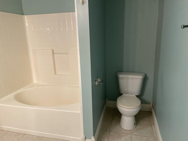 bathroom with a washtub, tile patterned flooring, and toilet