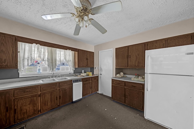 kitchen with a textured ceiling, ceiling fan, white fridge, and sink