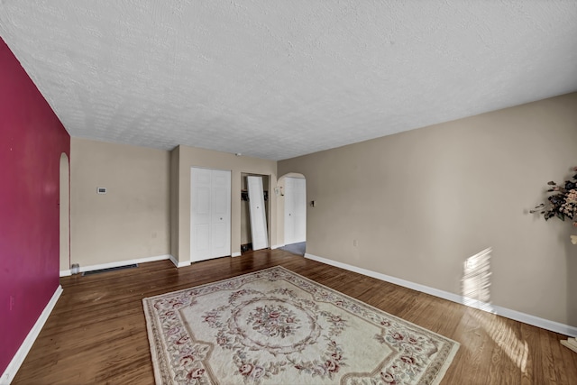 empty room featuring a textured ceiling and hardwood / wood-style flooring