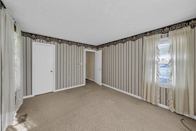 carpeted spare room with a textured ceiling