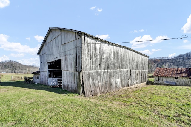 view of outdoor structure with a lawn and a mountain view