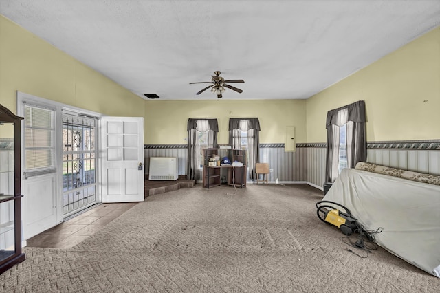 miscellaneous room featuring radiator, ceiling fan, carpet, and a textured ceiling