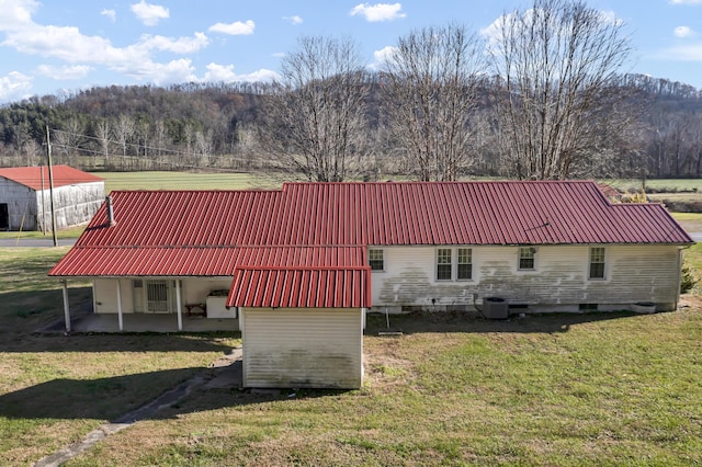 exterior space with a lawn, cooling unit, and a patio