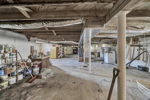 basement with water heater and washer / dryer