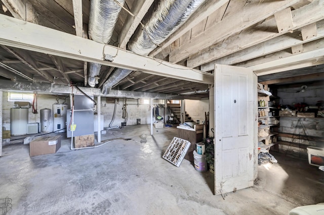 basement featuring electric water heater, gas water heater, and water heater