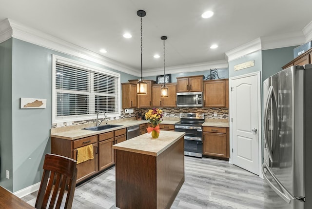 kitchen featuring crown molding, light wood-type flooring, decorative light fixtures, a kitchen island, and stainless steel appliances