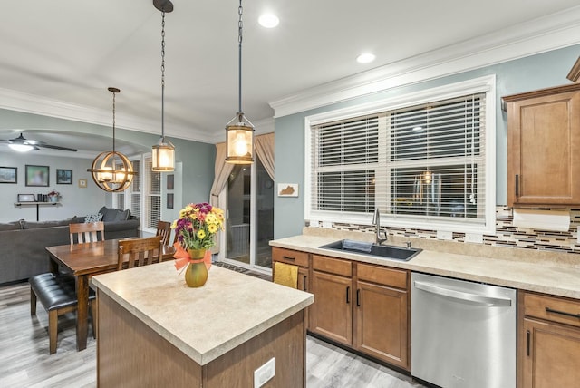 kitchen with decorative backsplash, ceiling fan with notable chandelier, sink, pendant lighting, and dishwasher