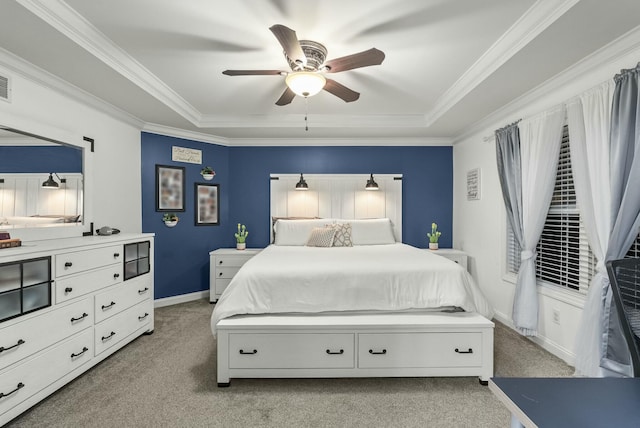 bedroom with light carpet, a tray ceiling, ceiling fan, and crown molding