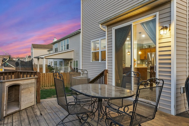 deck at dusk featuring a trampoline