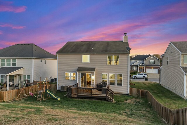 back house at dusk with a lawn, cooling unit, and a wooden deck