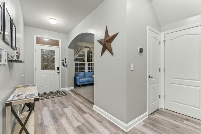 foyer entrance with lofted ceiling and light wood-type flooring