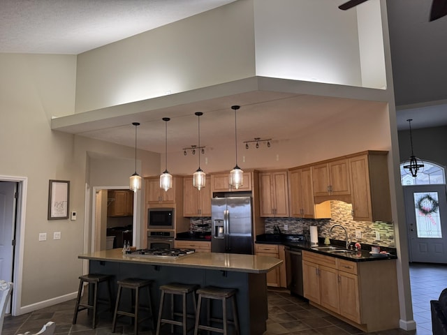 kitchen with a center island, sink, appliances with stainless steel finishes, and a high ceiling